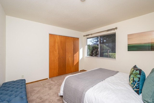 bedroom featuring baseboards, carpet floors, a textured ceiling, and a closet