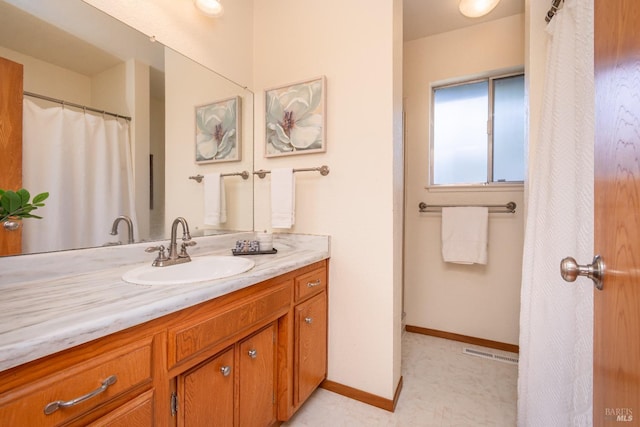 full bath featuring visible vents, vanity, and baseboards