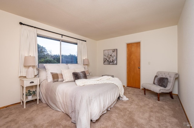 bedroom featuring light colored carpet and baseboards