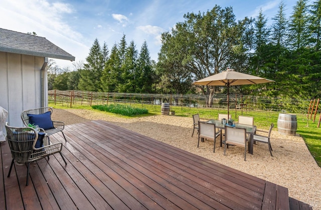 wooden deck featuring outdoor dining area and a fenced backyard