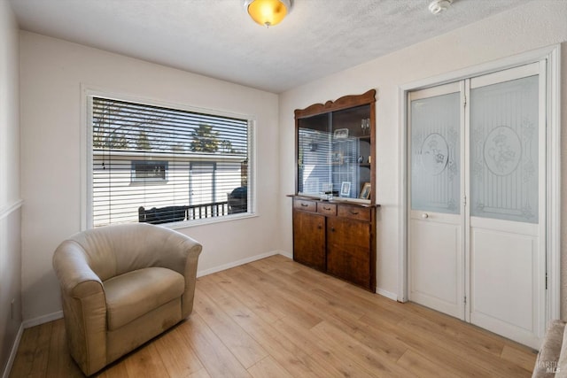 living area featuring light wood finished floors and baseboards