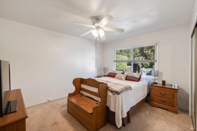 bedroom with light colored carpet and a ceiling fan