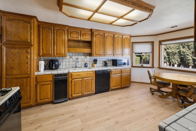 kitchen featuring visible vents, a sink, range with gas stovetop, backsplash, and dishwasher