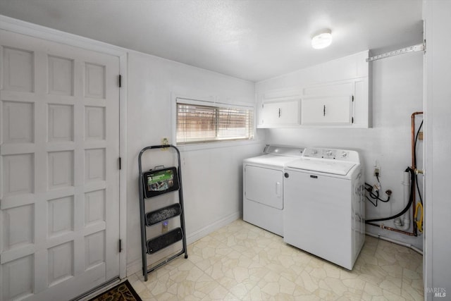 laundry room featuring washer and clothes dryer, light floors, cabinet space, and baseboards