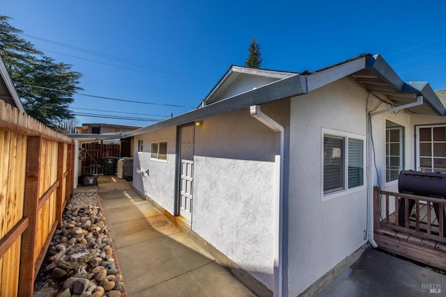 view of home's exterior featuring stucco siding and fence