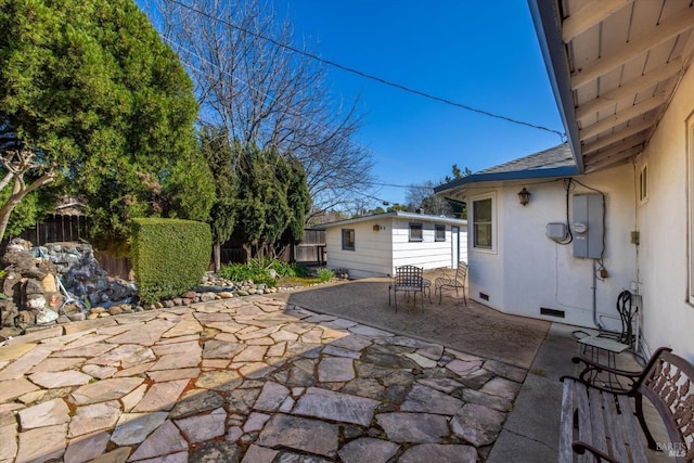 view of patio featuring an outbuilding and fence