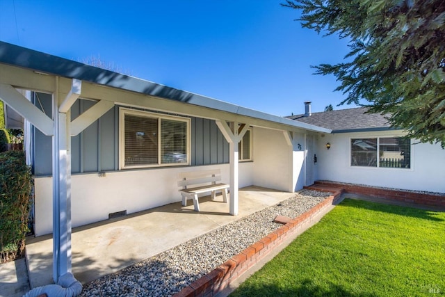 exterior space with board and batten siding, a shingled roof, stucco siding, a lawn, and crawl space