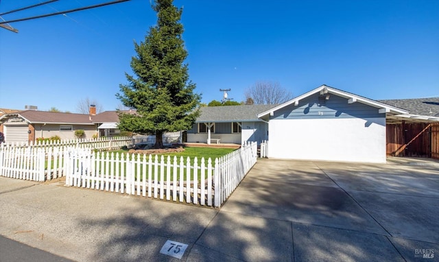 ranch-style home with concrete driveway, an attached garage, and a fenced front yard