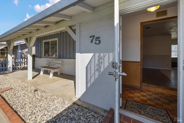 entrance to property with board and batten siding and visible vents