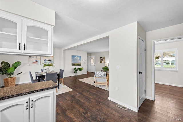 kitchen with dark wood finished floors, visible vents, dark stone countertops, and white cabinetry