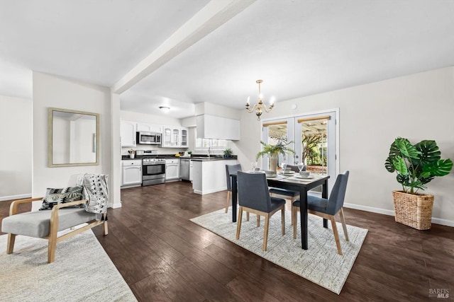 dining space featuring dark wood finished floors, baseboards, and an inviting chandelier