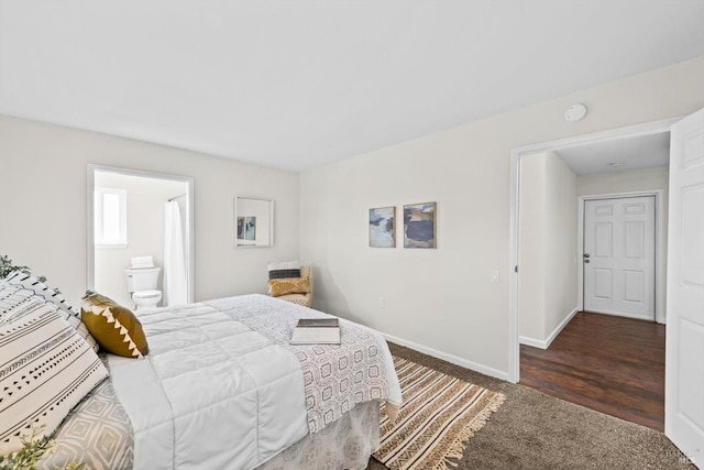 bedroom featuring dark colored carpet, connected bathroom, and baseboards