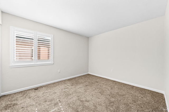 spare room featuring visible vents, carpet, and baseboards