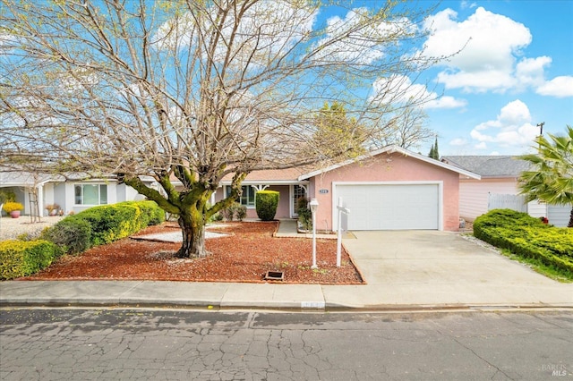 view of front of property featuring stucco siding, concrete driveway, and a garage