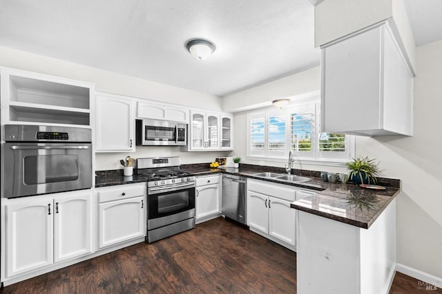 kitchen with a sink, appliances with stainless steel finishes, dark wood-style floors, white cabinets, and open shelves