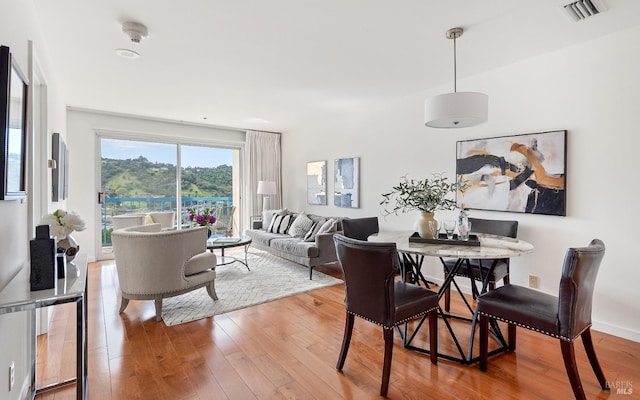 dining area featuring visible vents, baseboards, and hardwood / wood-style floors