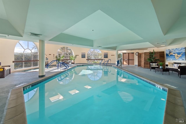 pool with a patio area and glass enclosure