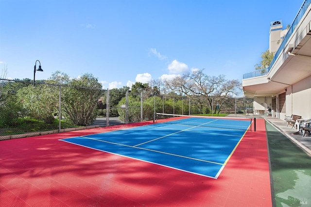 view of tennis court featuring fence