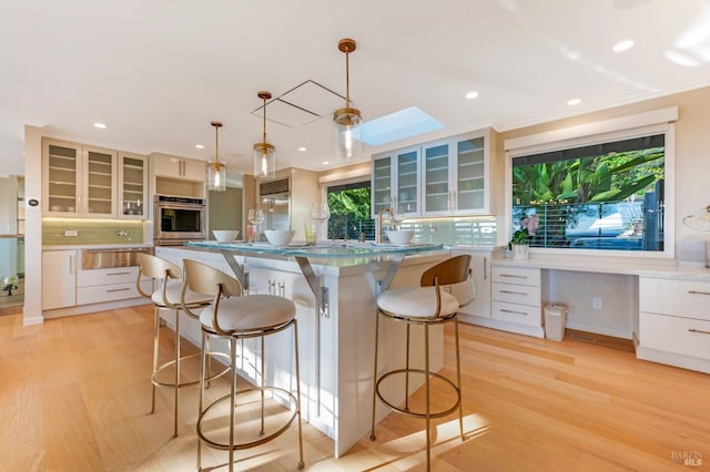 kitchen with a kitchen bar, decorative backsplash, and a warming drawer