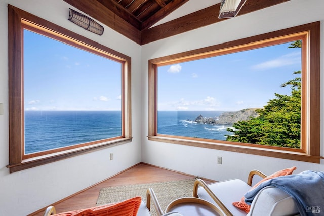 sitting room featuring lofted ceiling and a water view