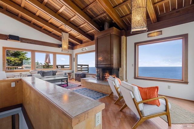 kitchen with open floor plan, a high end fireplace, wood-type flooring, wooden ceiling, and vaulted ceiling with beams