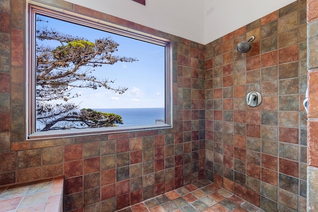 bathroom with a tile shower and stone finish flooring