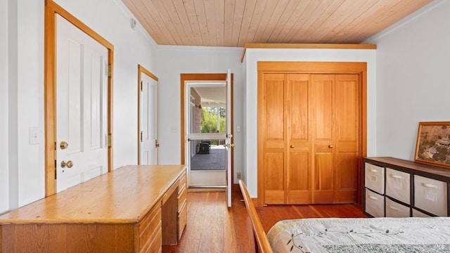 bedroom featuring wood ceiling, wood finished floors, and ornamental molding