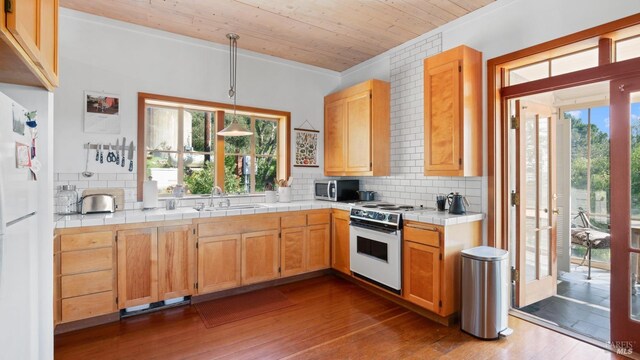 kitchen with a sink, tile countertops, white appliances, wood ceiling, and dark wood-style floors