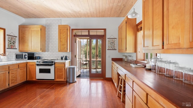 kitchen featuring stainless steel microwave, tasteful backsplash, crown molding, hardwood / wood-style flooring, and white range with electric cooktop