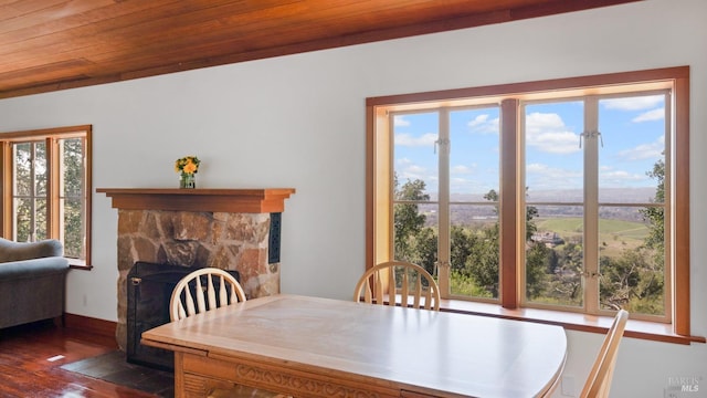 dining room featuring baseboards, a fireplace, and dark wood-style flooring