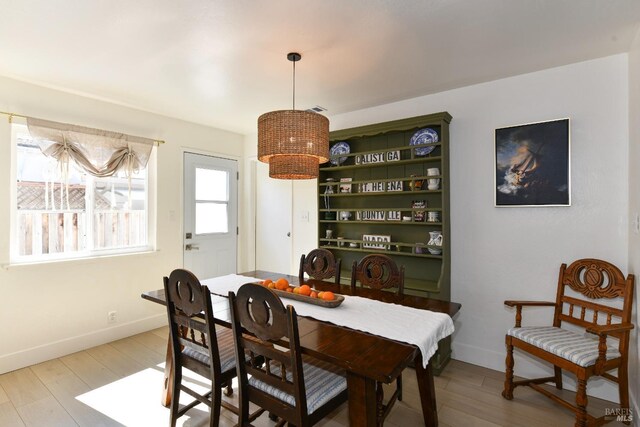 dining area featuring visible vents, baseboards, and light wood-style floors