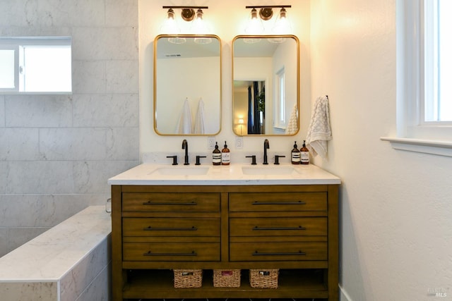 bathroom featuring double vanity, a wealth of natural light, and a sink