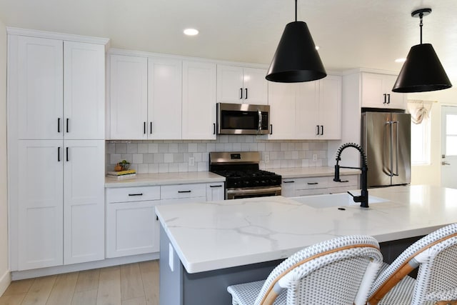 kitchen featuring white cabinetry, appliances with stainless steel finishes, and a breakfast bar