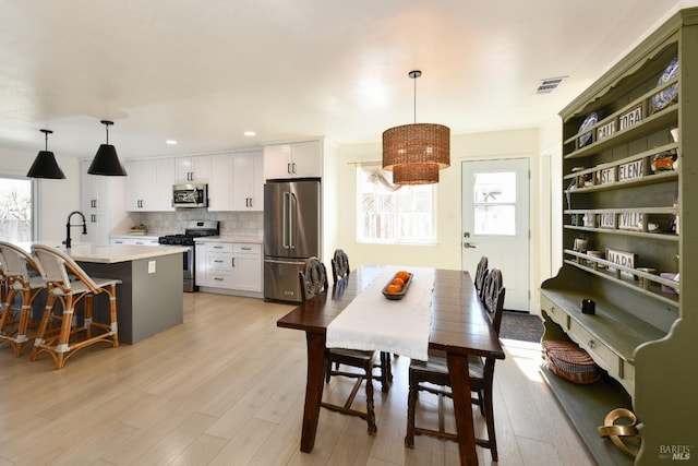 dining area with recessed lighting, visible vents, plenty of natural light, and light wood-style floors