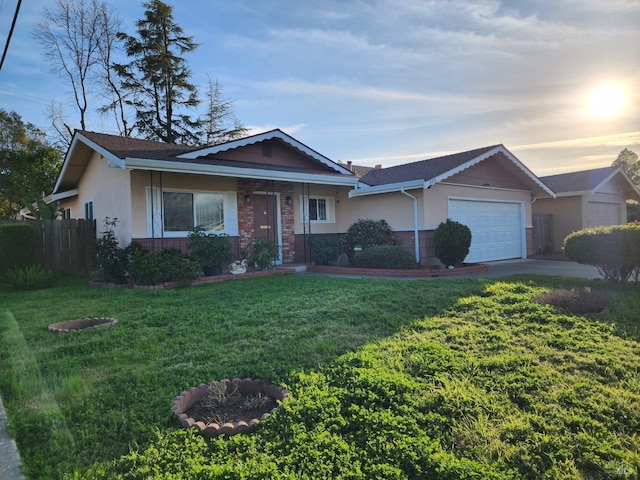 ranch-style house featuring fence, concrete driveway, a front yard, stucco siding, and an attached garage