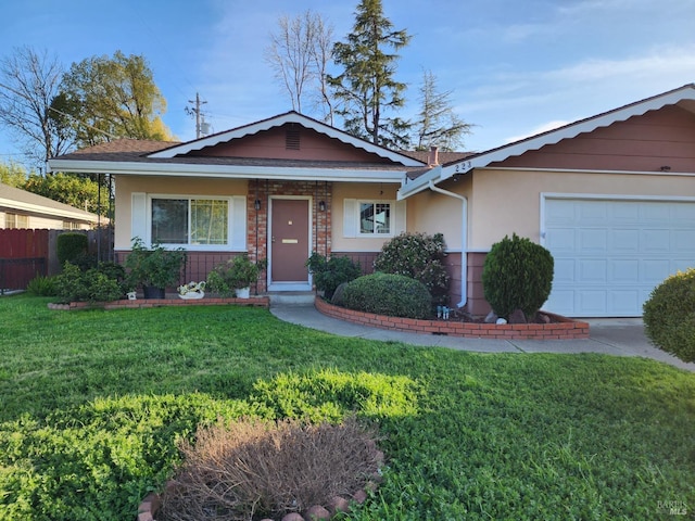 view of front of house with brick siding, a front lawn, fence, stucco siding, and an attached garage