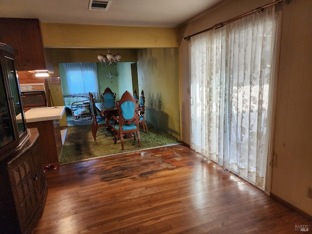 dining area featuring a chandelier, visible vents, and wood finished floors