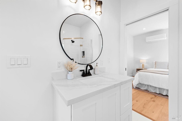 full bathroom with vanity, wood finished floors, a shower stall, ensuite bathroom, and a wall mounted air conditioner