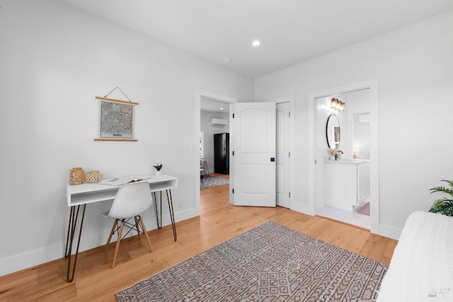 interior space with recessed lighting, baseboards, wood finished floors, and a wall mounted AC