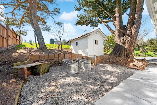 view of yard featuring an outdoor structure and fence