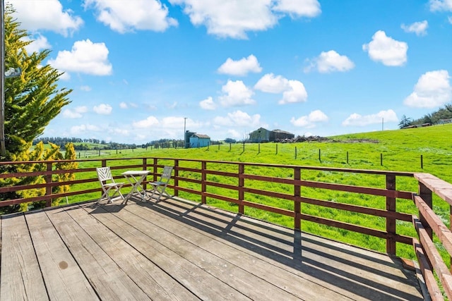 deck with a yard and a rural view