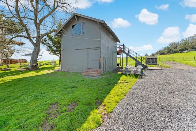 view of side of property featuring stairway, entry steps, a yard, and fence