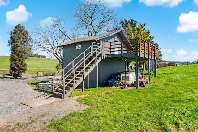 view of outdoor structure featuring driveway, a trampoline, stairs, and fence