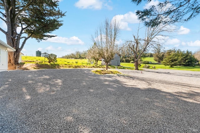 view of yard featuring gravel driveway and an outdoor structure