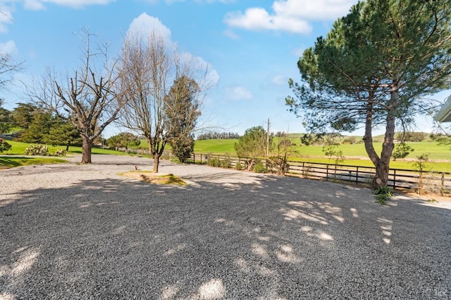 view of yard featuring a rural view and fence