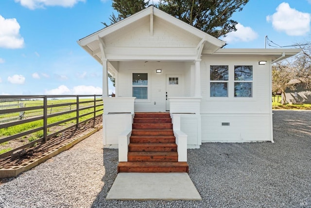 bungalow featuring crawl space, covered porch, and fence