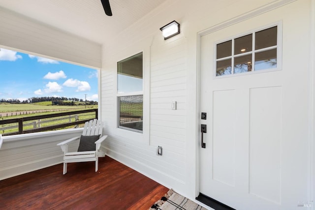 doorway to property with a rural view and a ceiling fan