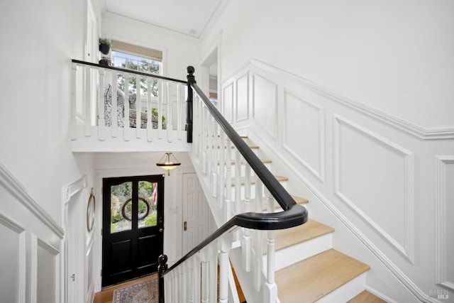 stairs featuring a wealth of natural light and crown molding