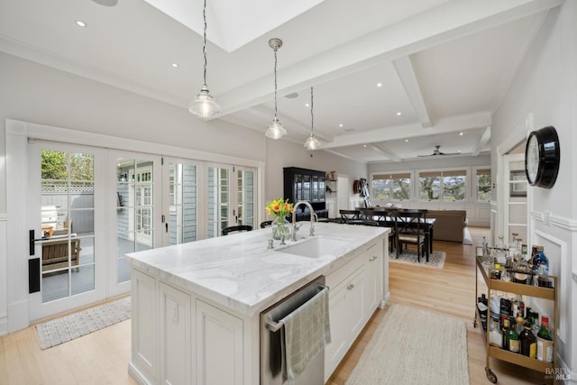 kitchen featuring a sink, open floor plan, french doors, beamed ceiling, and light wood-type flooring