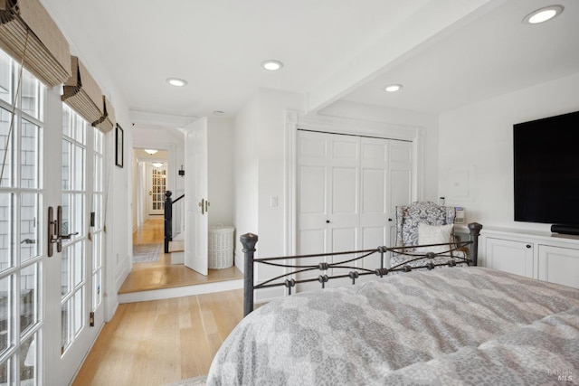 bedroom featuring light wood finished floors, recessed lighting, french doors, and a closet